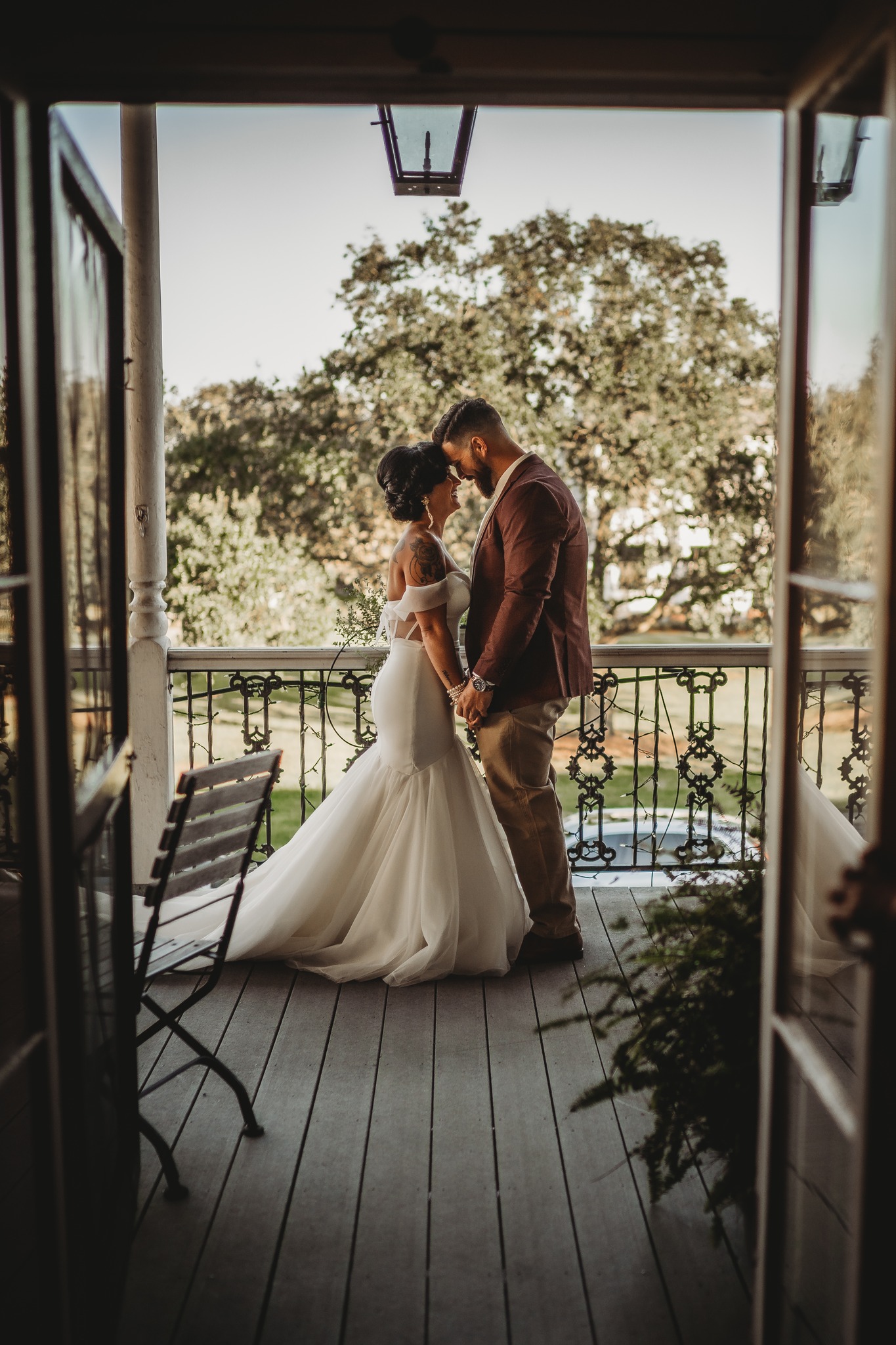Couple on wrought iron balcony at Maison De Tours historic wedding venue Saint Martinville Louisiana
