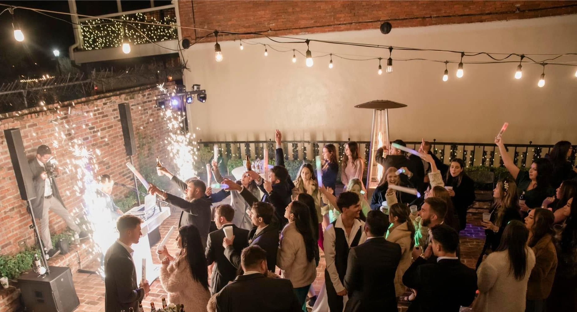 Wedding reception guests celebrating with sparklers at Maison De Tours outdoor courtyard Saint Martinville Louisiana